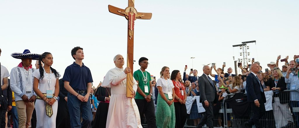 Jóvenes acompañan la cruz peregrina en una procesión